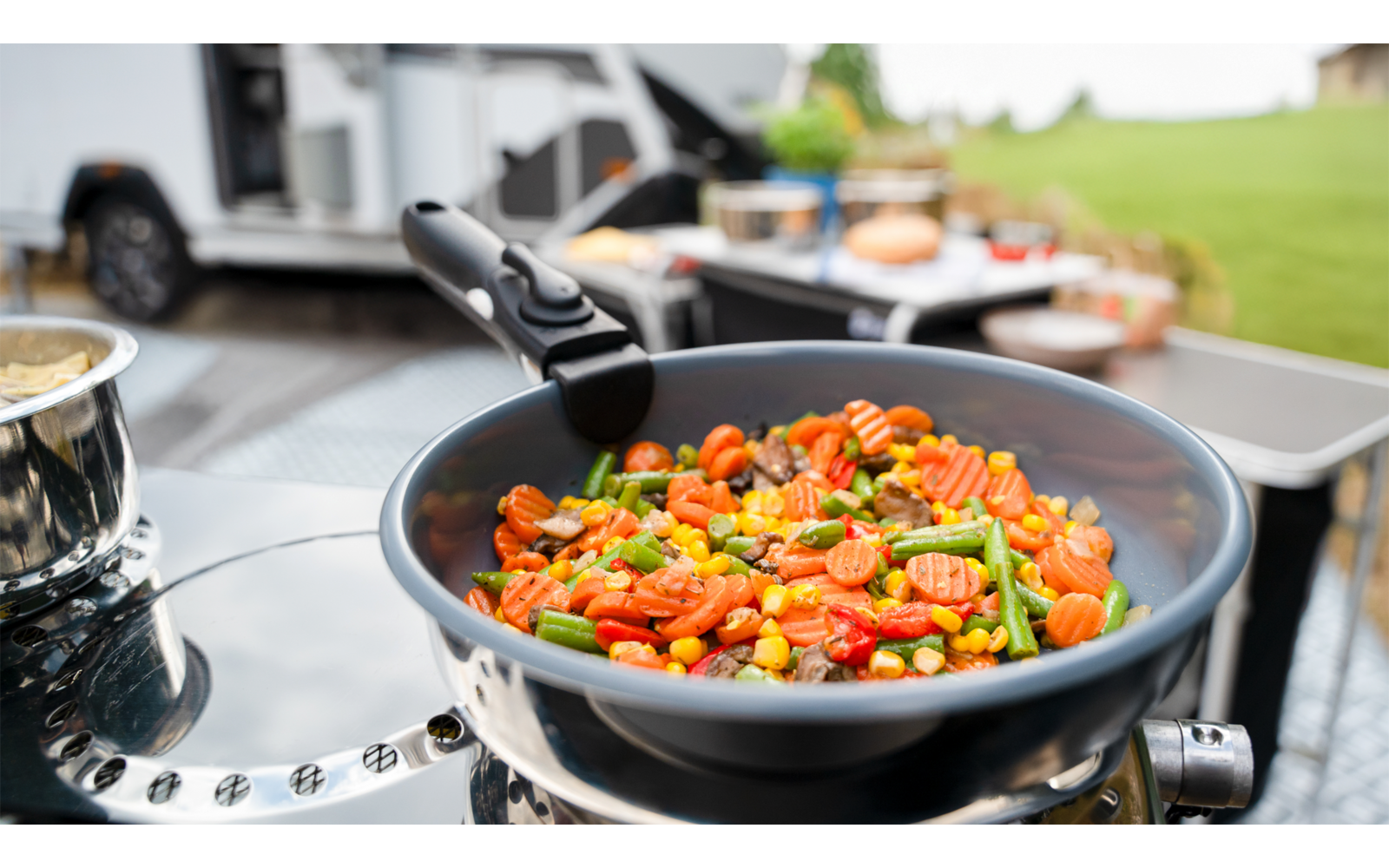Pfanne mit Tomaten und Gemüse auf einem Grill