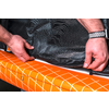 Hände rollen einen orangen Teppich mit weißen Linien aus