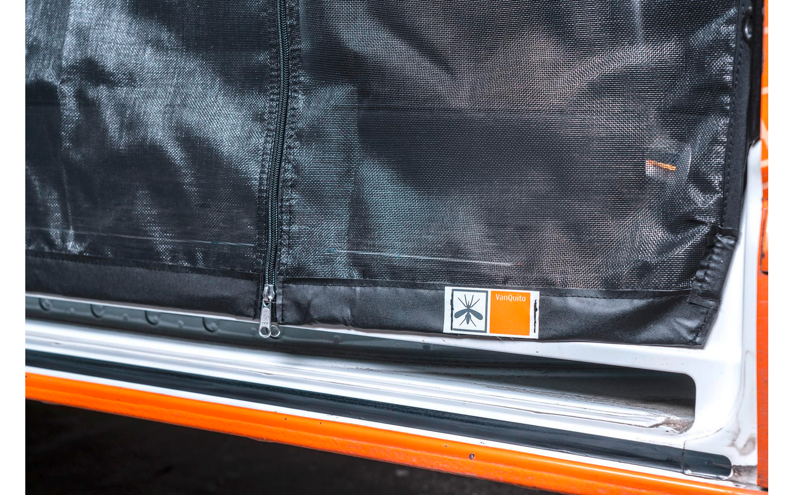 Nahaufnahme eines schwarzen Sicherheitsgurts in einem Fahrzeug mit orange-weißen Details