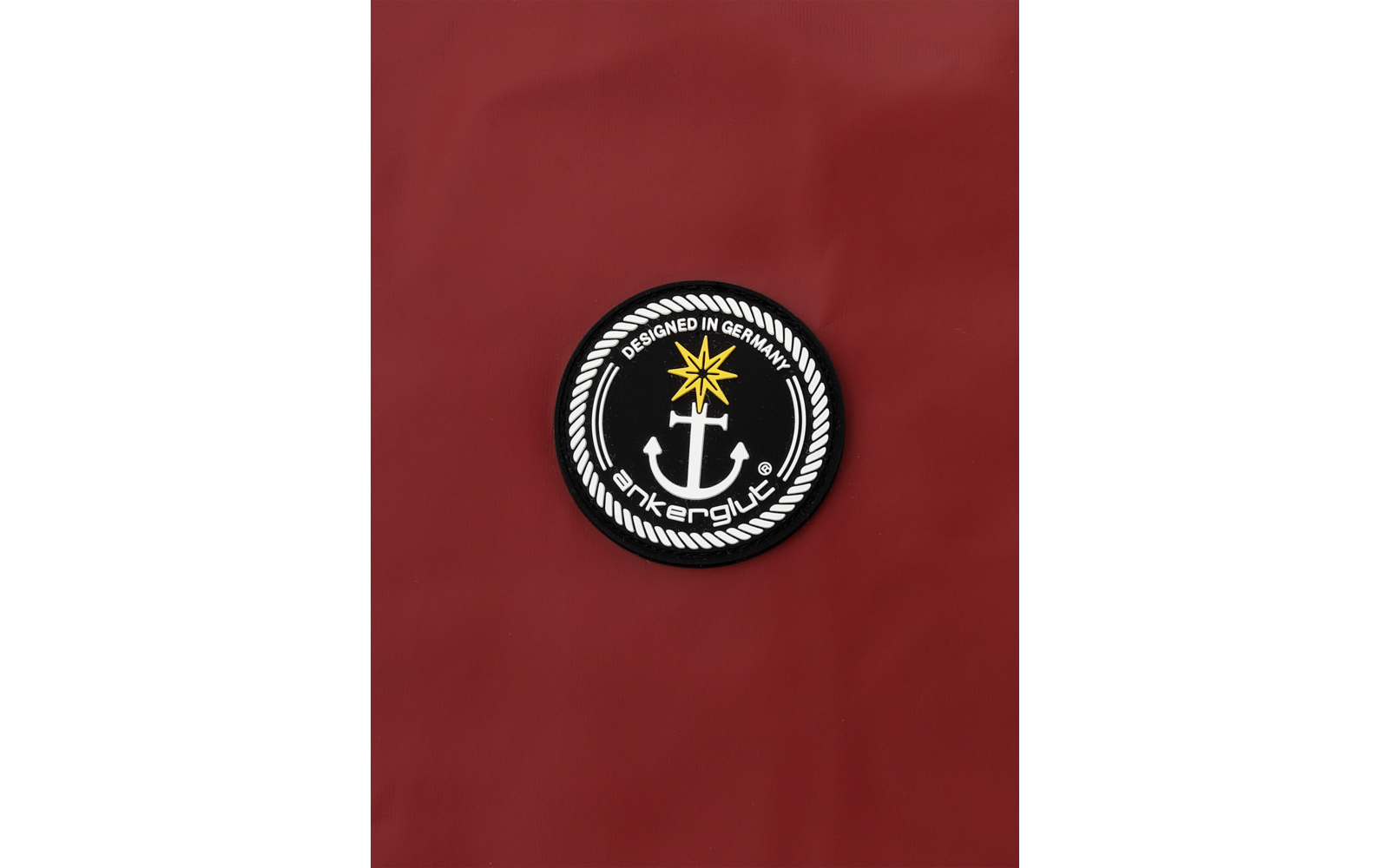 Schwarzer Anker in einem runden weiß-schwarzen Emblem mit einem goldenen Stern oben, auf rotem Hintergrund
