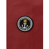 Schwarzer Anker in einem runden weiß-schwarzen Emblem mit einem goldenen Stern oben, auf rotem Hintergrund