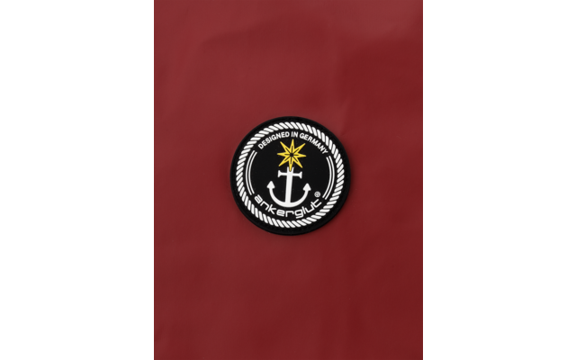 Schwarzer Anker in einem runden weiß-schwarzen Emblem mit einem goldenen Stern oben, auf rotem Hintergrund