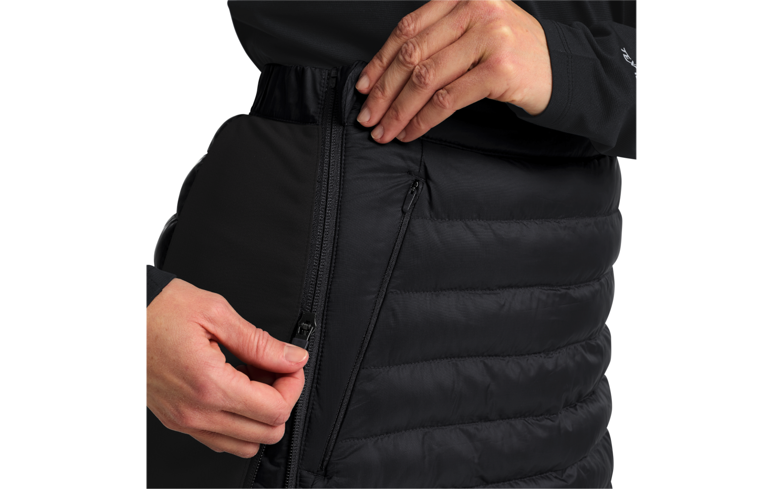 Person in schwarzer Jacke schließt den Reißverschluss einer schwarzen Steppjacke