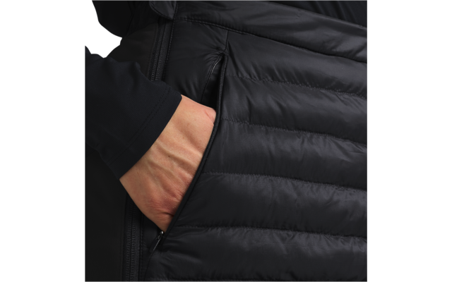 Hand steckt in der Seitentasche einer schwarzen Steppjacke