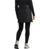 Person von hinten mit schwarzer gesteppter Jacke, schwarzem Rock und weißen Turnschuhen