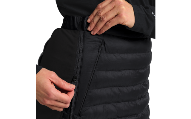 Person in schwarzer Jacke schließt den Reißverschluss einer schwarzen Steppjacke