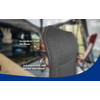 Gray textured chair backrest with mesh/3D‑mesh surface, two white arrows pointing to it, German text labels ('besonderer Stoff: 3D‑Mesh', 'gut gepolstert und schnell trocknend'), blurred background and blue curve at bottom