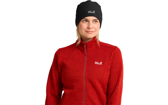 Person, bis zur Brust, rote Fleecejacke mit Reißverschluss und sichtbarem Logo, schwarze Mütze mit Logo, Blick leicht zur Seite