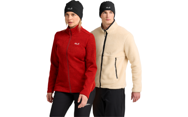 Frau und Mann mit schwarzen Mützen; Frau trägt rote Fleecejacke mit Reißverschluss; Mann trägt beige Sherpa-Fleecejacke mit schwarzem Reißverschluss und Reißverschlusstaschen; beide tragen schwarze Hosen