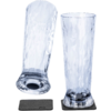 Two tall clear glasses with a faceted pattern; one stands on a dark square coaster, the other lies on its side on a second coaster