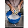 Handen scheppen water met een beker uit een blauwe emmer
