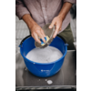 Handen wassen een bord boven een blauwe plastic kom met zeepsop
