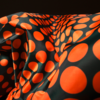 Black fabric with large orange polka dots and folds