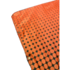 Orange fabric with black circular and diamond-shaped pattern and metal grommets along the edge