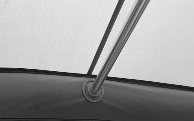 Intérieur d’un tissu clair avec une tige métallique verticale fixée par un anneau en plastique circulaire au bord du tissu