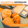 Récipient rond contenant trois viennoiseries (petit pain clair, croissant, petit pain aux graines) sur une table ; assiette avec morceaux de fromage et de beurre en arrière-plan ; bandes de texte orange avec écriture