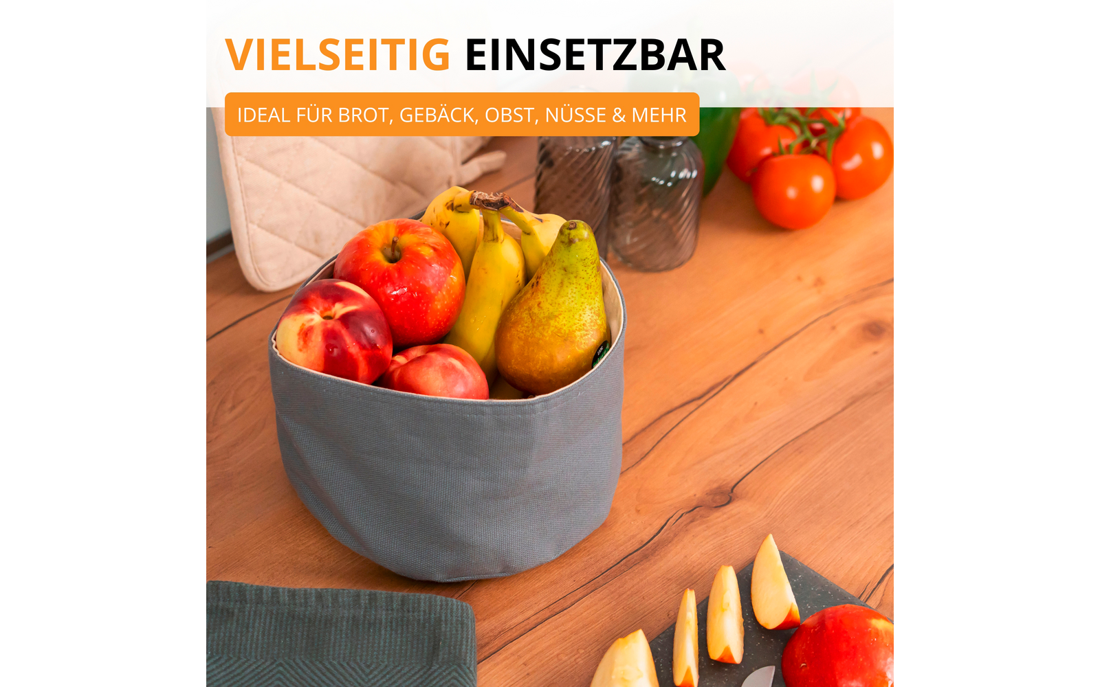 Panier en tissu avec pommes, poires et bananes sur une table en bois ; quartiers de pomme tranchés sur une planche, tomates, deux vases en verre et un textile matelassé en arrière-plan. Texte visible en haut : "VIELSEITIG EINSETZBAR" et "IDEAL FÜR BROT, GEBÄCK, OBST, NÜSSE & MEHR"