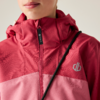 Unteres Gesicht (Mund und Kinn) einer Person, die eine zweifarbige rot-rosa Kapuzenjacke mit hochgezogenem Reißverschluss trägt; schwarzer Riemen diagonal über der Brust, kleines graues Logo auf der Jacke