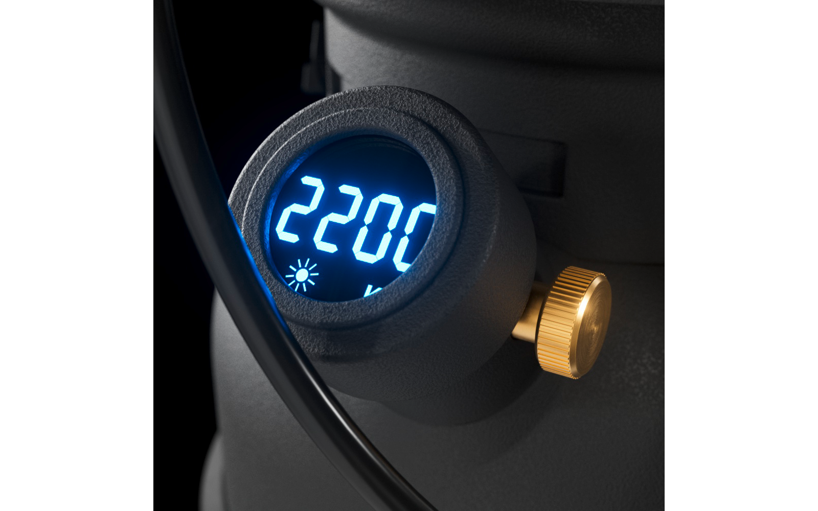 Display digitale rotondo illuminato di blu con indicazione 2200 e icona del sole, accanto a una manopola dorata zigrinata e a un cavo nero
