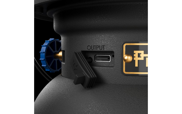 Primo piano di un involucro nero strutturato con una porta USB-C etichettata 'OUTPUT', un coperchio in gomma nero parzialmente aperto, una manopola blu zigrinata e una targhetta con cornice dorata