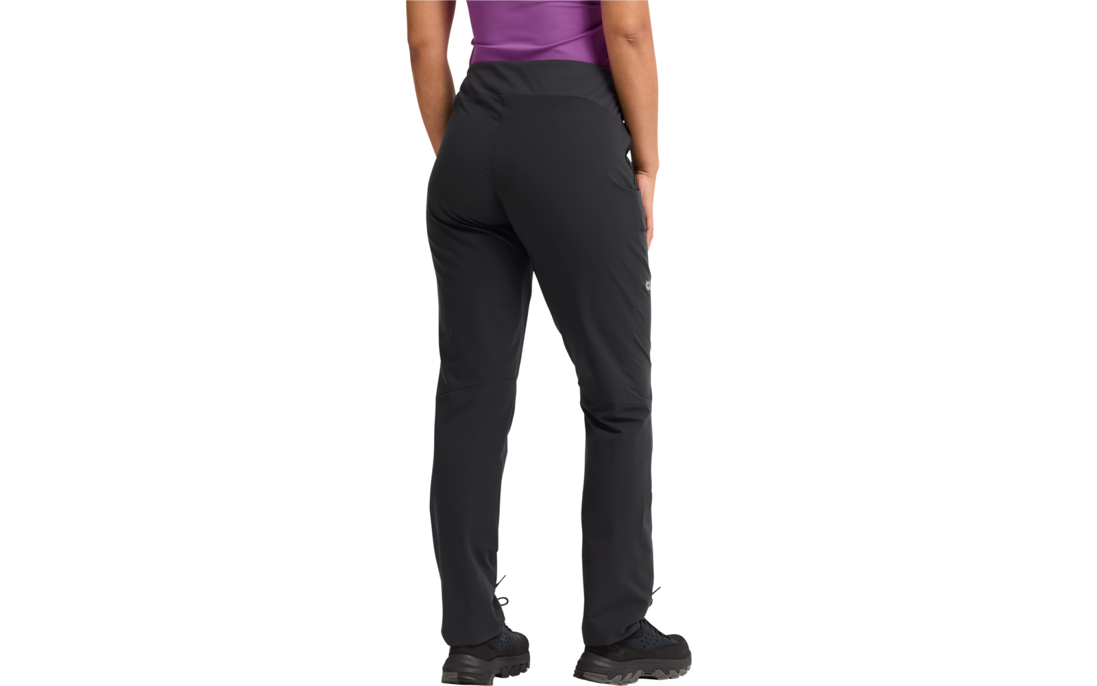 Rückenansicht einer Person von Taille bis Knöchel, schwarze Hose, sichtbare violette Oberteilkante, dunkle Schuhe