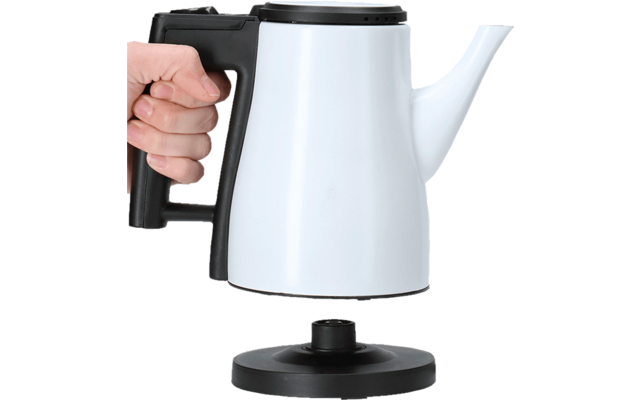 Hand holding white electric kettle with black handle over a round base