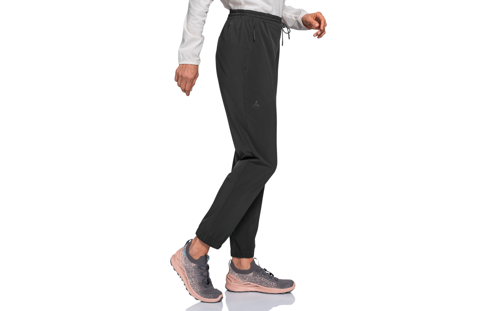 Unterkörper einer Person in schwarzen Jogginghosen mit Kordelzug und elastischen Bündchen, hellrosa-graue Sportschuhe, weiße Langarm-Ärmel, weißer Hintergrund