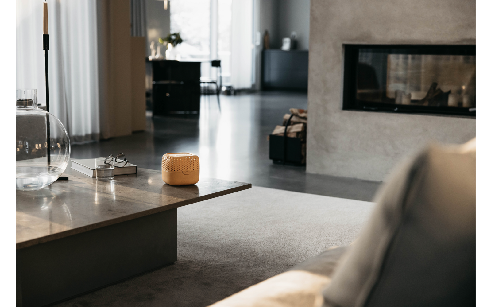 Moderner Wohnraum mit Sofa, großem Fenster und Kamin