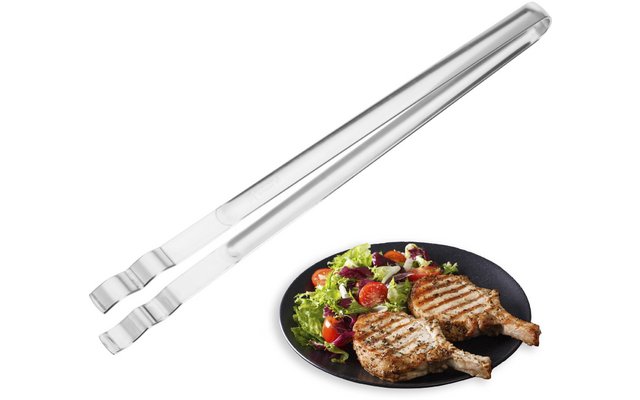 Longue pince métallique argentée à côté d'une assiette noire avec deux côtelettes marquées au gril et une salade mélangée