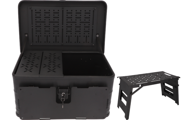 Malle noire en plastique ouverte avec couvercle perforé, fermeture métallique et clé ; à droite, un petit tabouret noir à assise perforée