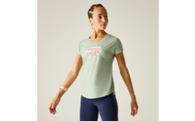 Frau steht, blickt zur Seite, trägt hellgrünes T‑Shirt mit rosa Motiv, dunkelblaue Leggings, geflochtene Haare und Uhr am linken Handgelenk