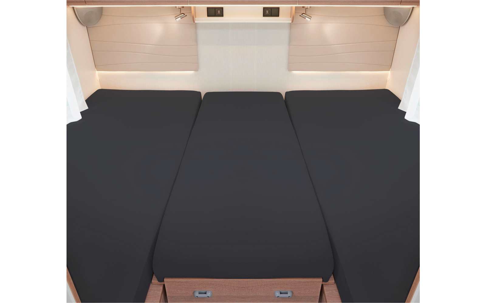 Trois matelas noirs côte à côte sur un cadre en bois dans une pièce lumineuse