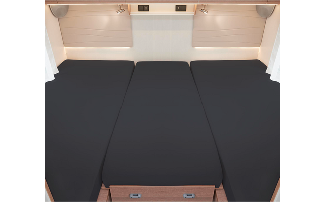 Trois matelas noirs côte à côte sur un cadre en bois dans une pièce lumineuse