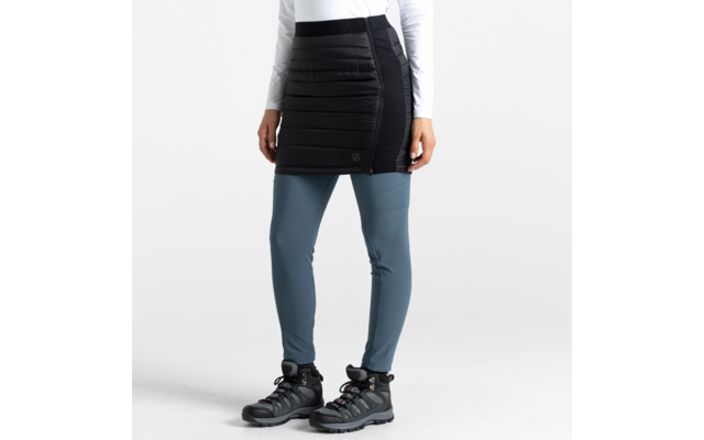 Partie inférieure du corps d'une femme portant un pantalon jupe noir, des leggings bleus et des chaussures noires sur fond blanc
