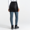 Personne vue de dos portant une jupe noire par-dessus un legging bleu et des bottes noires