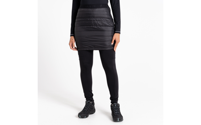 Femme portant une jupe noire, des leggings noirs et des chaussures noires, debout sur fond blanc