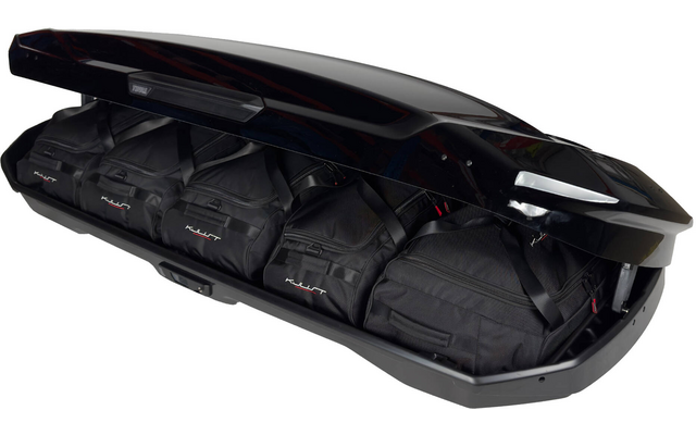 Coffre de toit noir ouvert contenant quatre sacs de voyage noirs