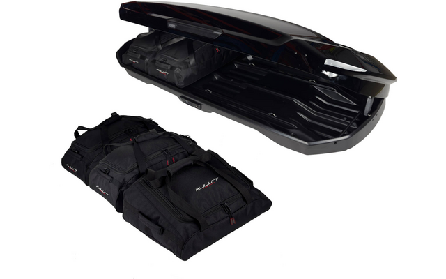 Coffre de toit noir ouvert avec des sacs de voyage noirs à côté et partiellement à l'intérieur, sur fond blanc