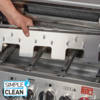 Hand hält ein rechteckiges Edelstahlblech im Inneren eines Gasgrills; darunter Drehknöpfe, Bedienelemente und ein "SIMPLE CLEAN"-Logo