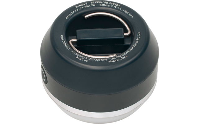 Rundes schwarzes Gerät mit silbernem Rand, oben ein zusammenklappbarer Metallbügel und ein rechteckiger Griff, weißer Beschriftungstext am oberen Rand und Einschaltsymbol an der Seite