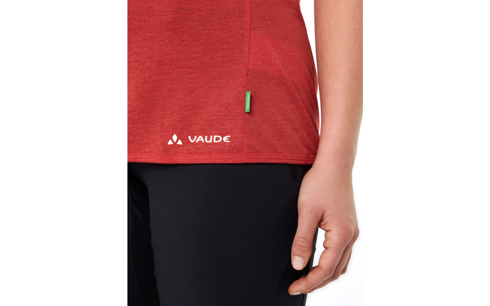 Rumpf einer Person mit rotem T-Shirt mit weißem VAUDE-Logo und schwarzer Hose, rechte Hand seitlich sichtbar
