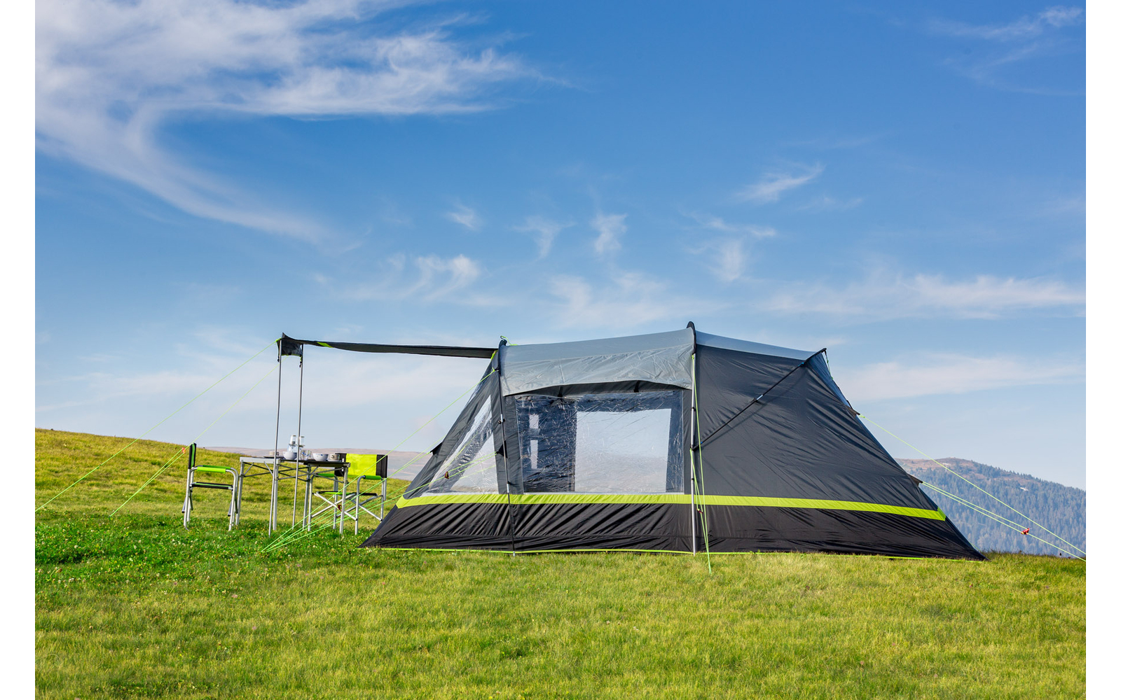 Großes Zelt auf einer grünen Wiese unter blauem Himmel mit wenigen Wolken