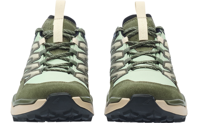 Pair of green and beige shoes side by side, front view, laces and black treaded soles visible