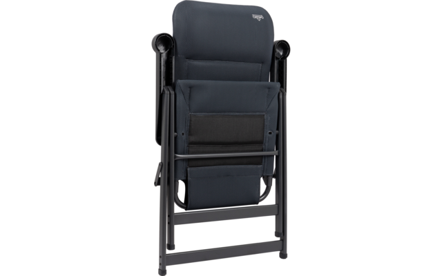 Chaise pliante gris foncé pliée avec revêtement en tissu, armature métallique noire et accoudoirs visibles