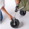 Person befestigt ein Vorderrad an einem Kinderwagen