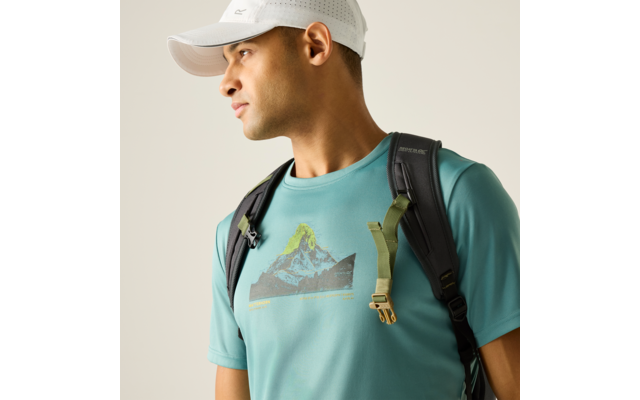 Person mit weißer Baseballkappe, türkisfarbenem T‑Shirt mit Bergmuster und schwarzem Rucksack, schaut nach links