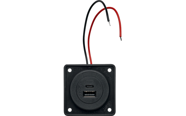Schwarze quadratische Montageplatte mit rundem Einsatz, sichtbare USB-A- und USB-C-Buchsen und zwei abisolierte Kabel (rot, schwarz)