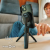 Smartphone auf kleinem Dreibein-Stativ auf einem Tisch, eine Hand berührt das Gerät, eine sitzende Person im Hintergrund, Logos 'silwy' und 'FIDLOCK' unten links