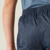 Close-up van heup- en onderrug van een persoon met donkerblauwe shorts met elastische taille en een blauw bovenstuk, zichtbare arm