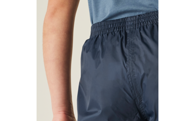 Close-up van heup- en onderrug van een persoon met donkerblauwe shorts met elastische taille en een blauw bovenstuk, zichtbare arm